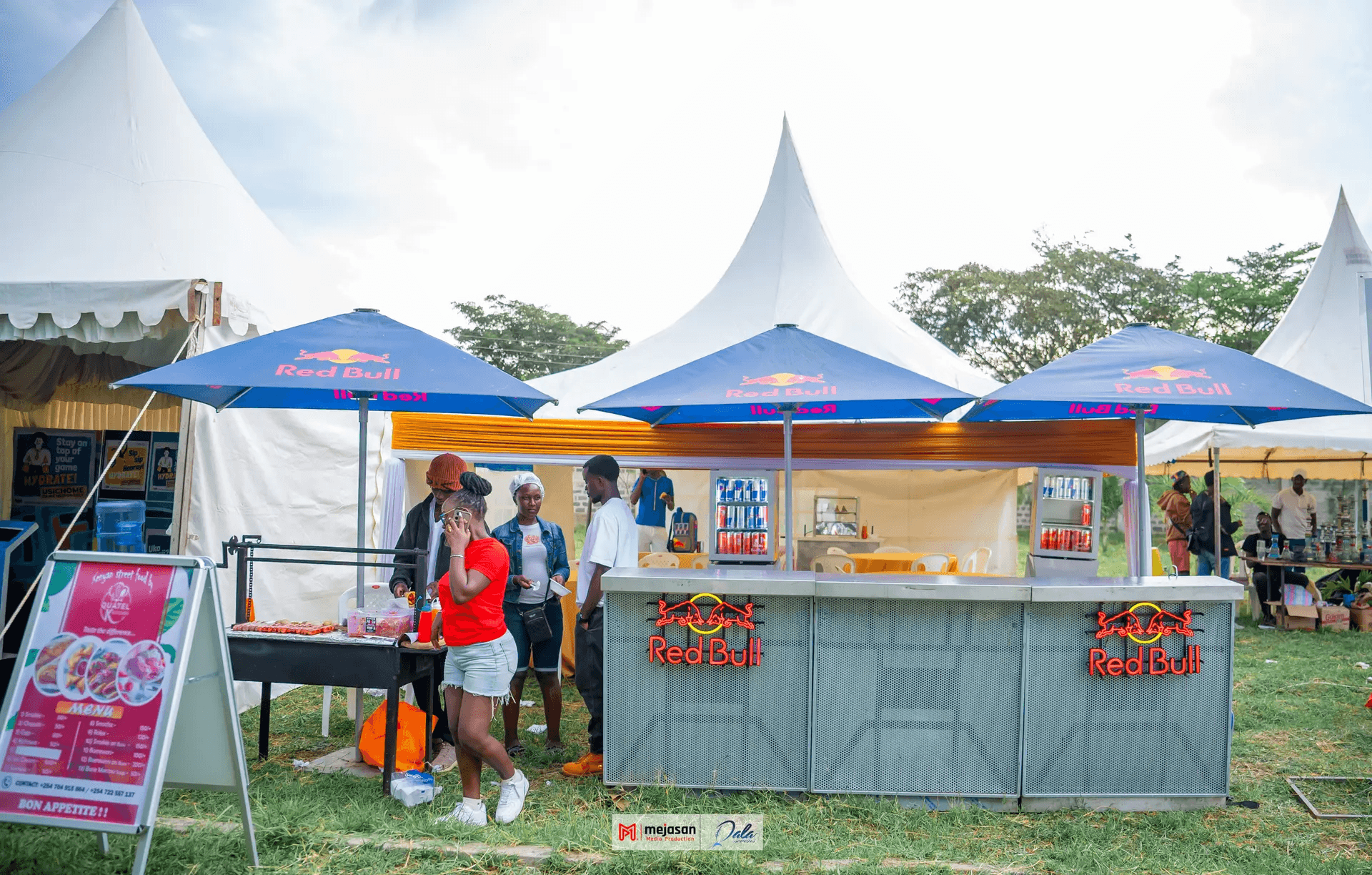 A festival ground with branded tents and crowds